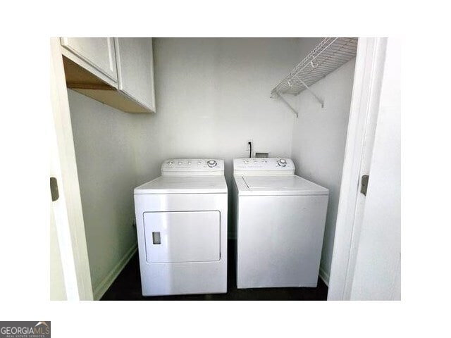 laundry room featuring independent washer and dryer and cabinets