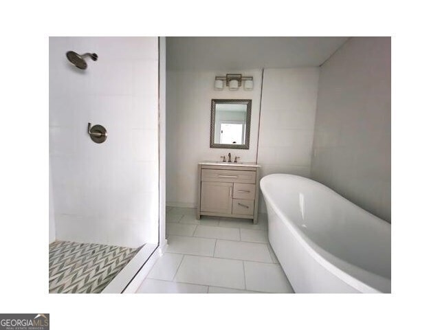 bathroom with shower with separate bathtub, tile patterned floors, and vanity