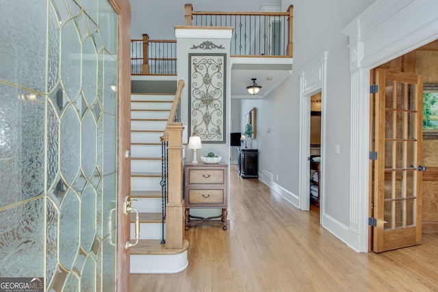 foyer entrance with light wood-type flooring and crown molding