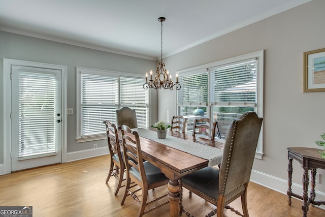 dining space with light wood-type flooring, a notable chandelier, and crown molding