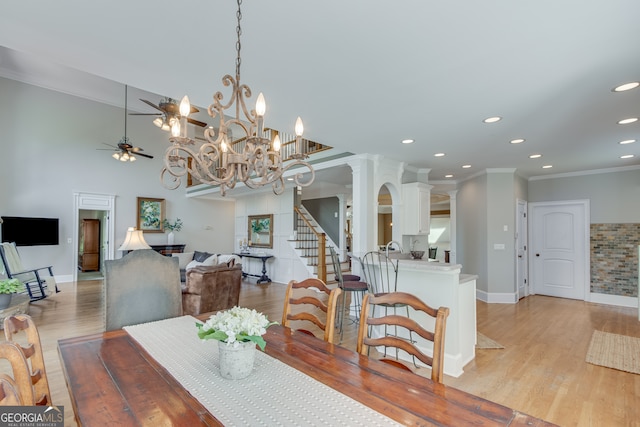 dining space with ceiling fan with notable chandelier, ornamental molding, and light hardwood / wood-style flooring