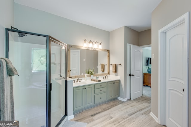 bathroom with hardwood / wood-style floors, vanity, and a shower with shower door