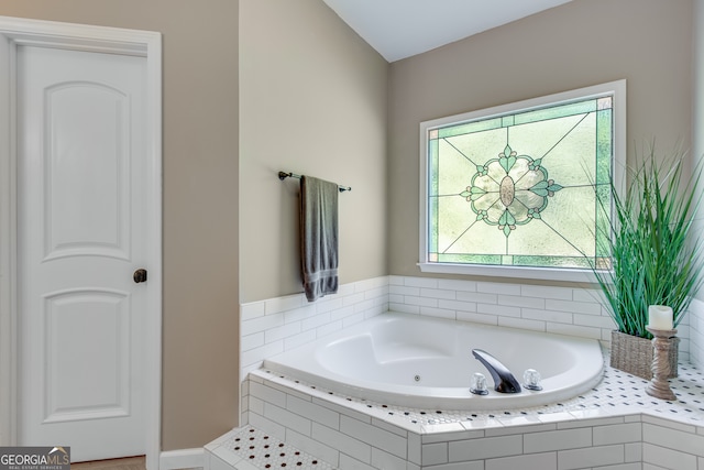 bathroom with a wealth of natural light and tiled tub