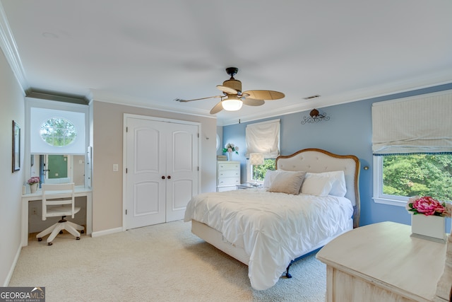 carpeted bedroom featuring ornamental molding, multiple windows, ceiling fan, and a closet