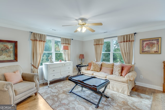 living room featuring a wealth of natural light, crown molding, ceiling fan, and light hardwood / wood-style flooring