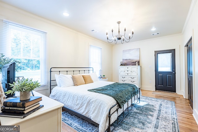 bedroom featuring wood-type flooring, crown molding, and a chandelier