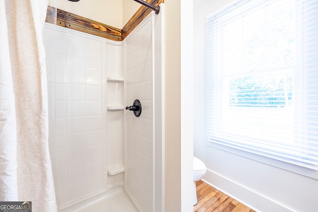 bathroom featuring wood-type flooring, toilet, and a shower with shower curtain