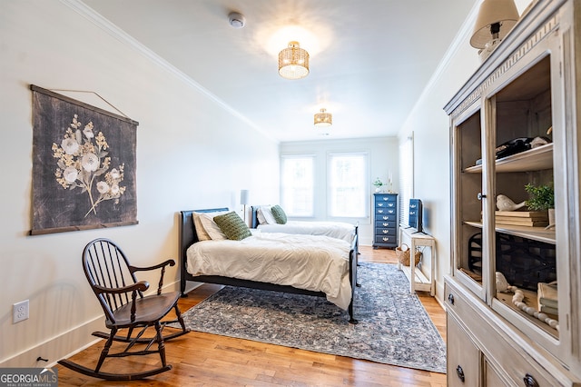 bedroom featuring crown molding and light hardwood / wood-style flooring