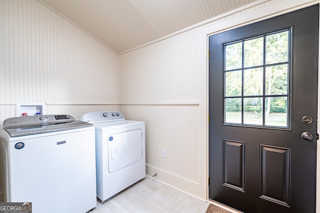 washroom with washer and clothes dryer and wood walls