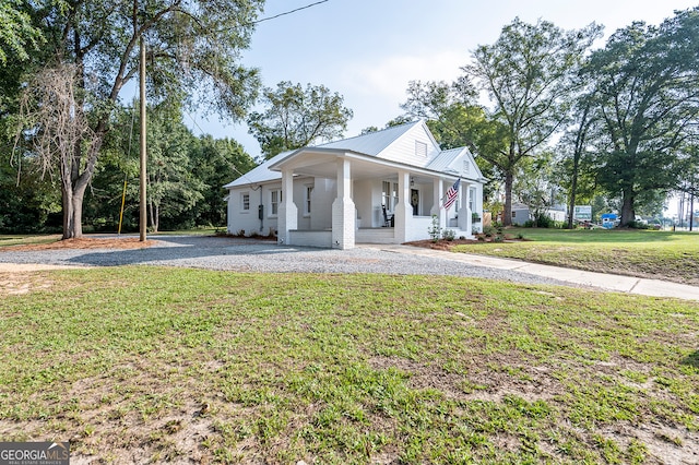 greek revival house featuring covered porch and a front yard