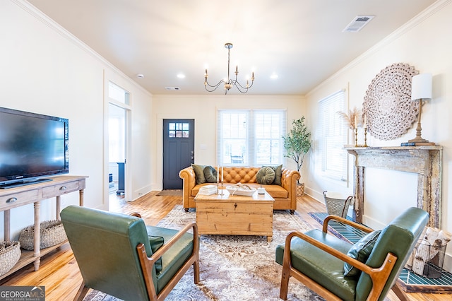 living room with a notable chandelier, light wood-type flooring, and ornamental molding