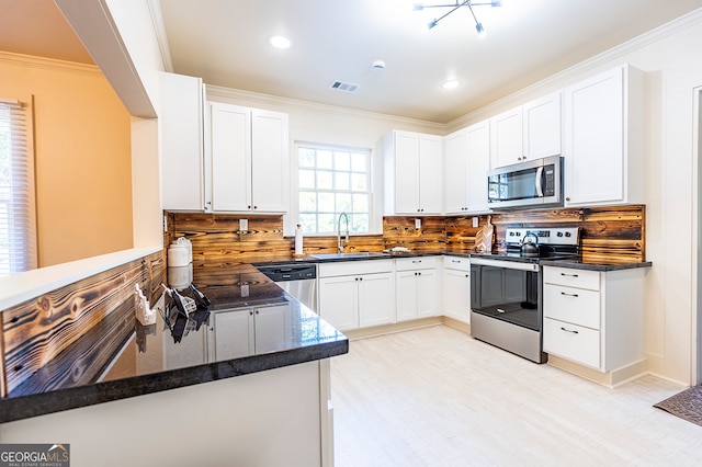 kitchen with white cabinets, sink, kitchen peninsula, tasteful backsplash, and stainless steel appliances