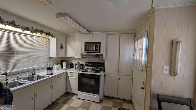 kitchen with light countertops, a sink, light floors, stainless steel microwave, and electric range