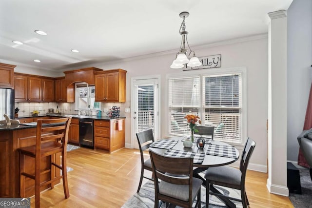 dining space featuring light hardwood / wood-style flooring, a notable chandelier, sink, and crown molding