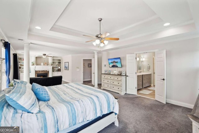 carpeted bedroom featuring connected bathroom, ceiling fan, a raised ceiling, and crown molding