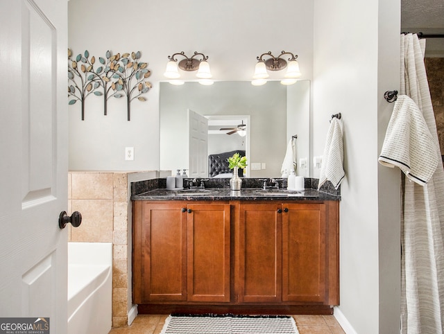 bathroom featuring ceiling fan, vanity, a tub, tile patterned floors, and tile walls