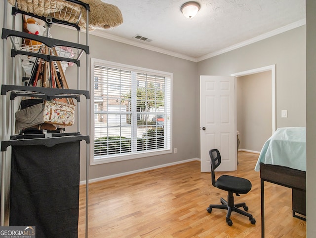 office with a textured ceiling, ornamental molding, and light hardwood / wood-style flooring