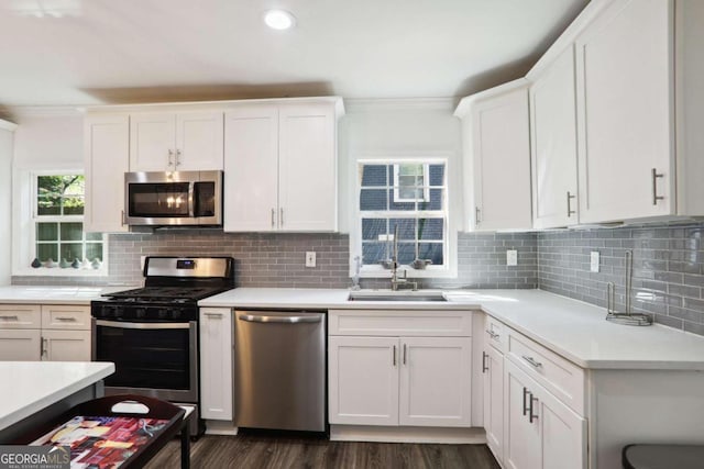 kitchen featuring decorative backsplash, white cabinetry, and stainless steel appliances