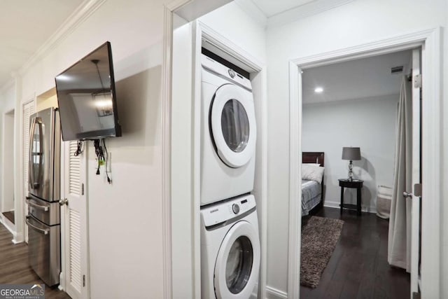 laundry area featuring ornamental molding, stacked washer and dryer, and dark hardwood / wood-style flooring