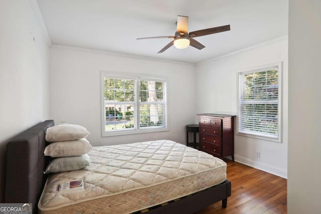 bedroom with multiple windows, ornamental molding, dark hardwood / wood-style floors, and ceiling fan