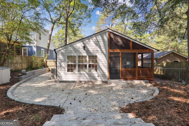 rear view of property featuring a sunroom and a patio