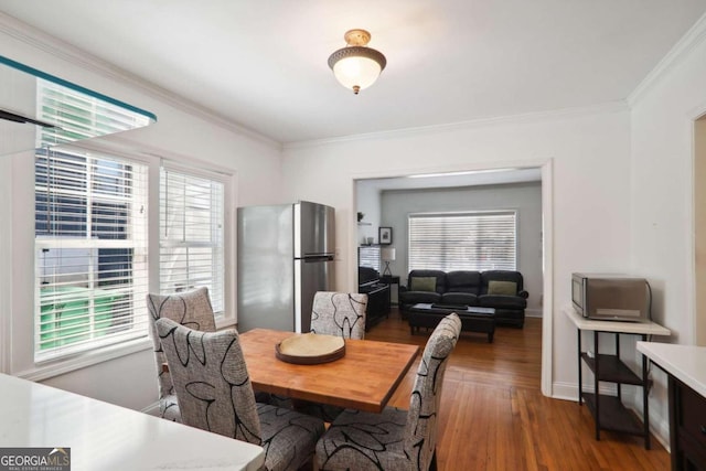 dining space with crown molding, a healthy amount of sunlight, and dark hardwood / wood-style flooring