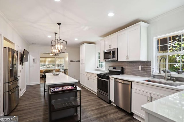 kitchen featuring stainless steel appliances, plenty of natural light, sink, and white cabinetry