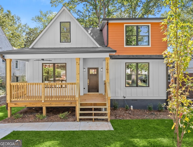 rear view of house with a lawn and a porch