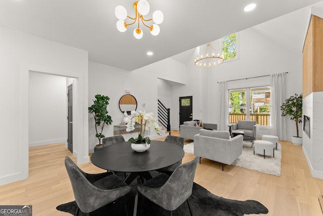 dining room featuring light hardwood / wood-style flooring, a chandelier, and high vaulted ceiling