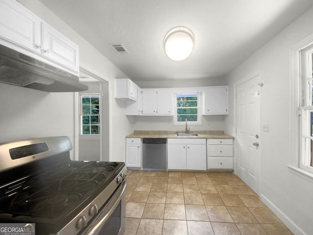 kitchen with light tile patterned floors, stainless steel appliances, sink, and white cabinetry