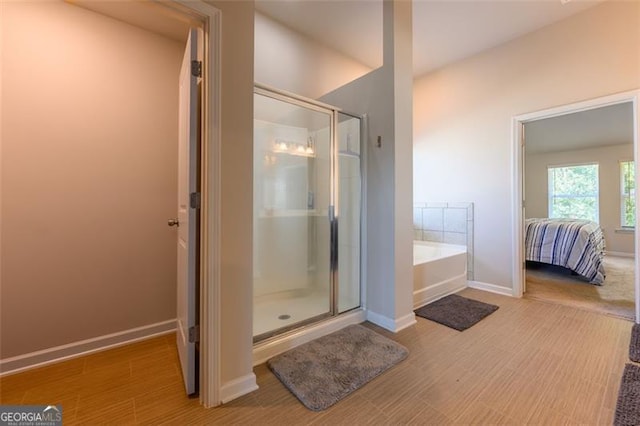 bathroom featuring wood-type flooring and plus walk in shower