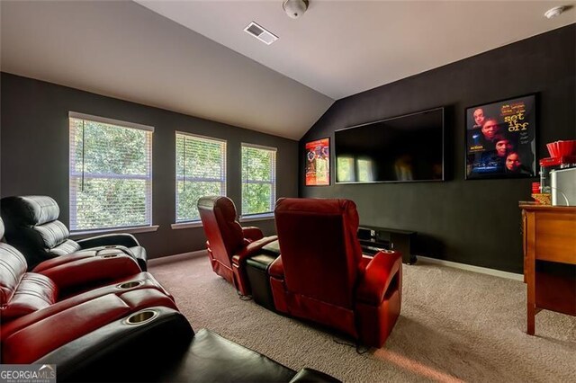 cinema room featuring plenty of natural light, vaulted ceiling, and carpet