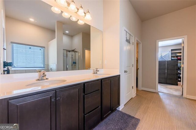 bathroom featuring walk in shower, vanity, and hardwood / wood-style flooring