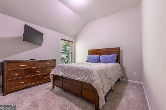 carpeted bedroom featuring lofted ceiling