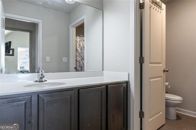 bathroom with vanity, hardwood / wood-style floors, and toilet