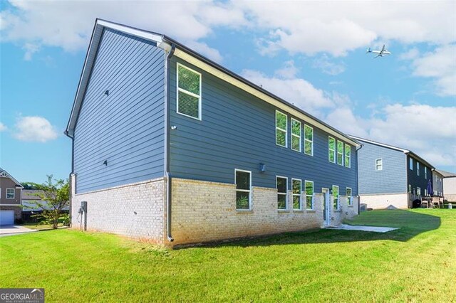 rear view of house featuring a yard