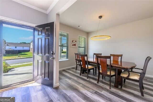 dining space featuring hardwood / wood-style floors and crown molding