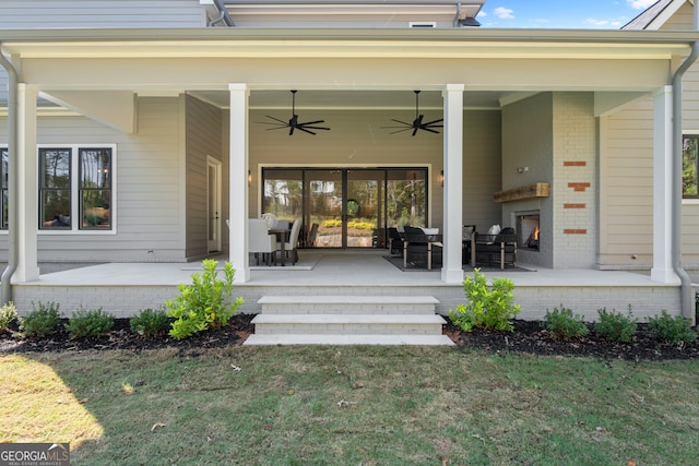 entrance to property with ceiling fan, outdoor lounge area, and a yard