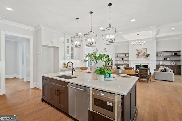 kitchen featuring light wood-type flooring, a kitchen island with sink, white cabinetry, coffered ceiling, and appliances with stainless steel finishes