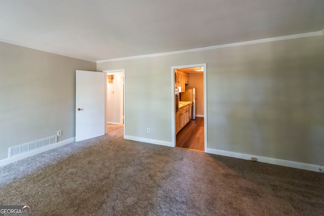 empty room featuring dark carpet and ornamental molding