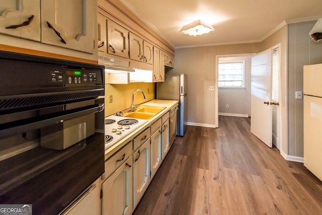 kitchen featuring dark hardwood / wood-style flooring, sink, ornamental molding, and appliances with stainless steel finishes