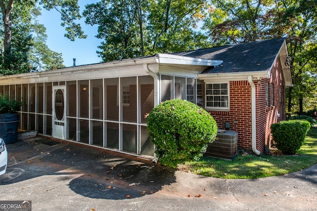 view of side of property featuring a sunroom and central AC