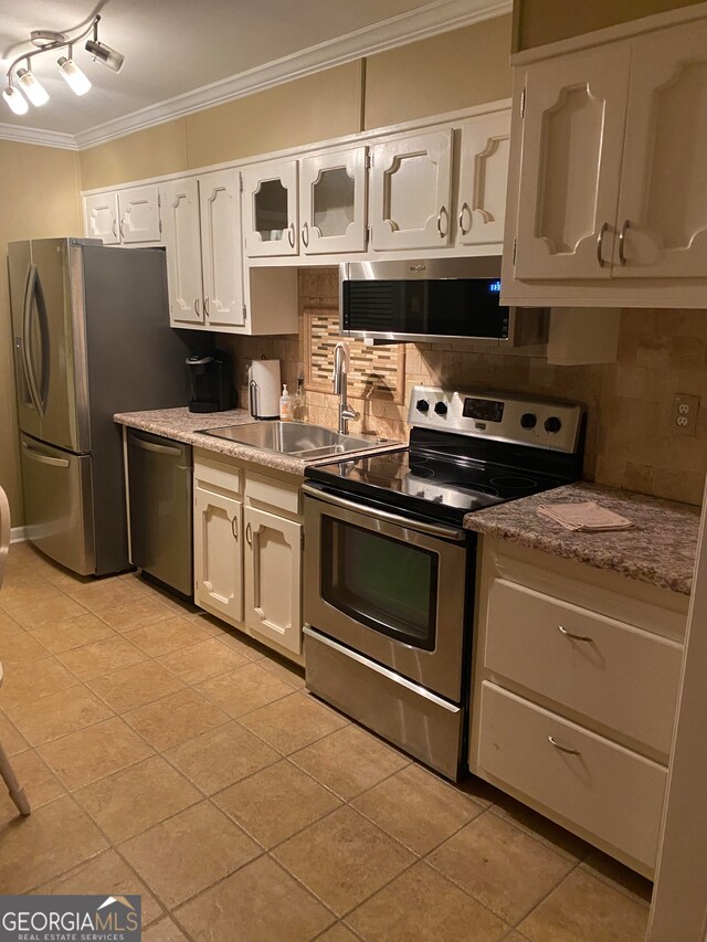 kitchen featuring stainless steel appliances, white cabinetry, tasteful backsplash, and sink