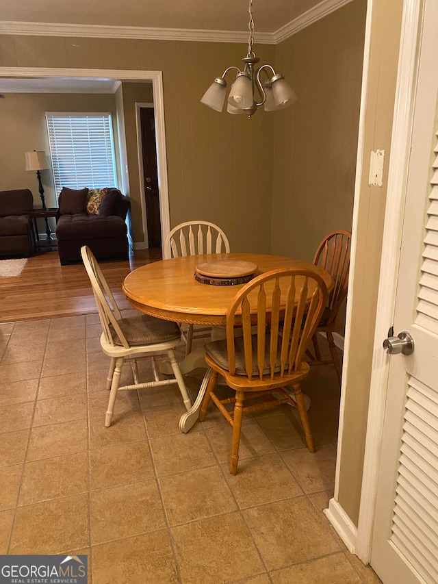 dining space featuring wood-type flooring, an inviting chandelier, and ornamental molding