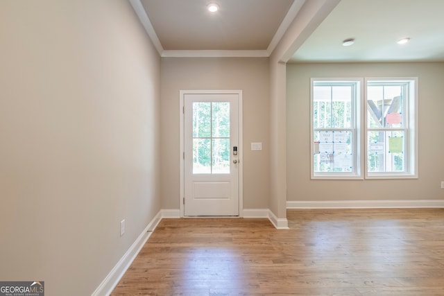 entryway with ornamental molding, light hardwood / wood-style flooring, and plenty of natural light