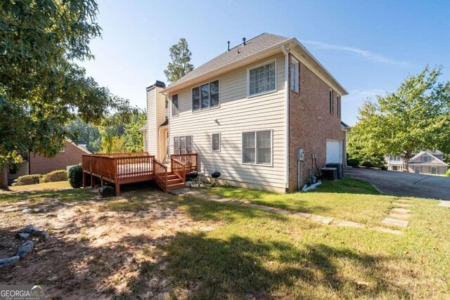 back of property featuring a lawn, central AC unit, and a deck