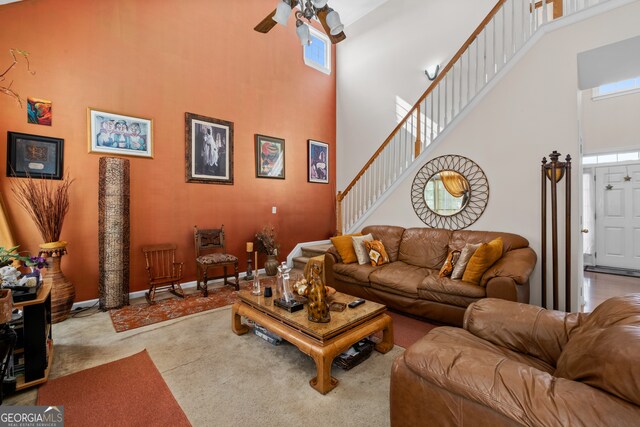 carpeted living room with a towering ceiling and ceiling fan