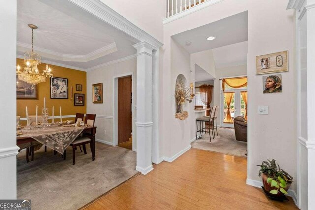 dining area featuring light hardwood / wood-style floors, ornamental molding, and decorative columns