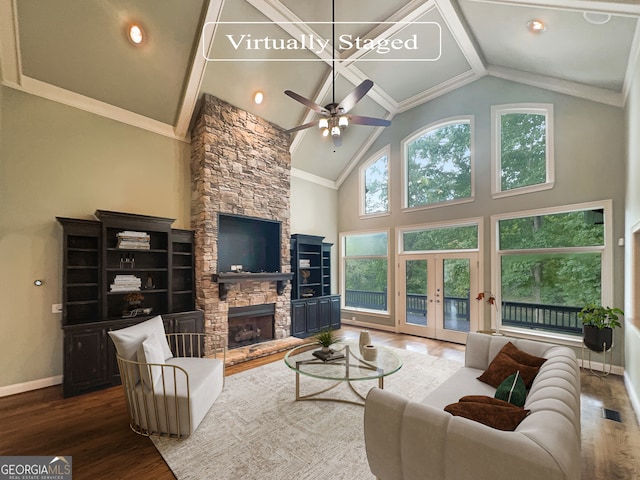 living room featuring ceiling fan, high vaulted ceiling, hardwood / wood-style flooring, a fireplace, and crown molding