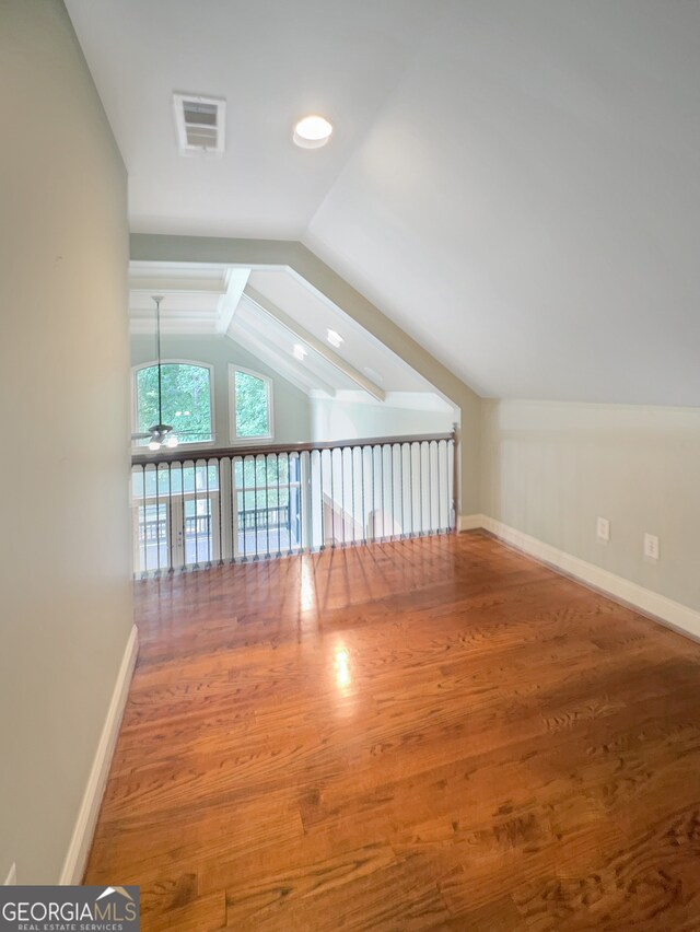 additional living space featuring vaulted ceiling and hardwood / wood-style floors